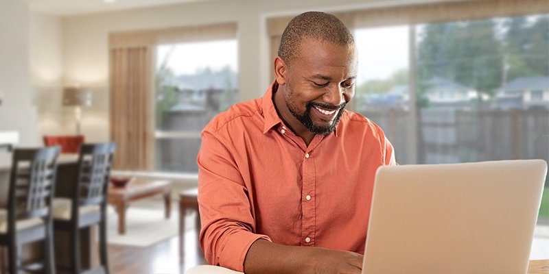 smiling man working on his laptop