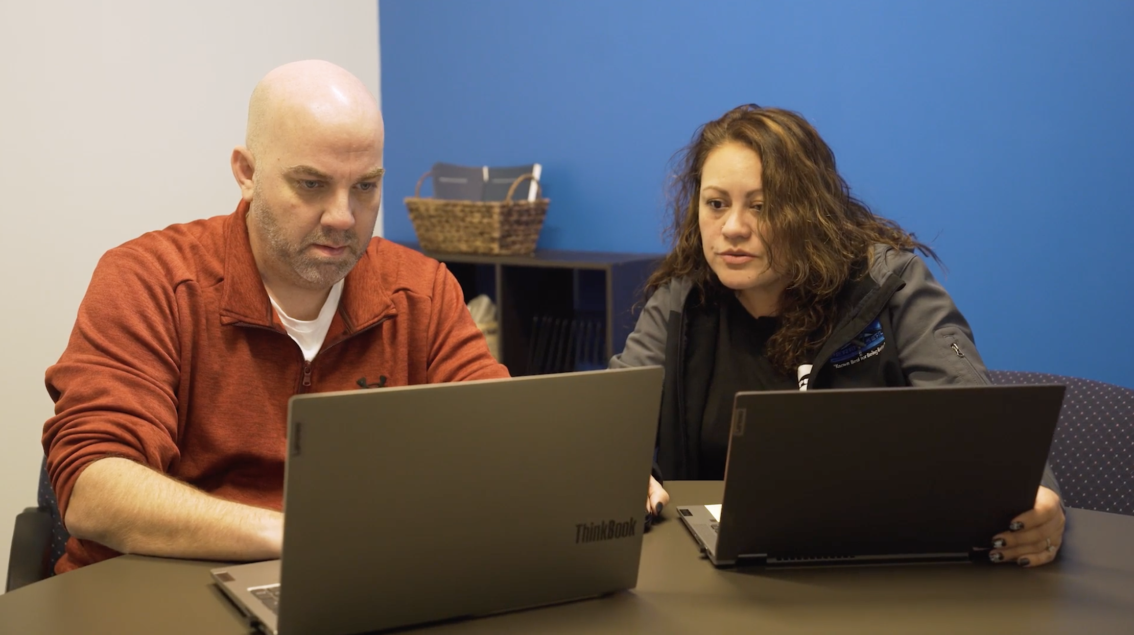 A man and a woman sharing ideas on there laptops