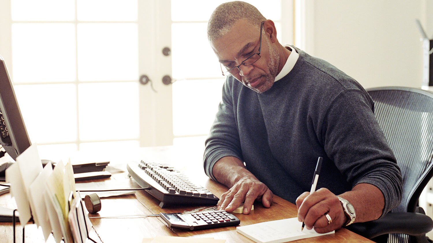 mature man working at desk on finances