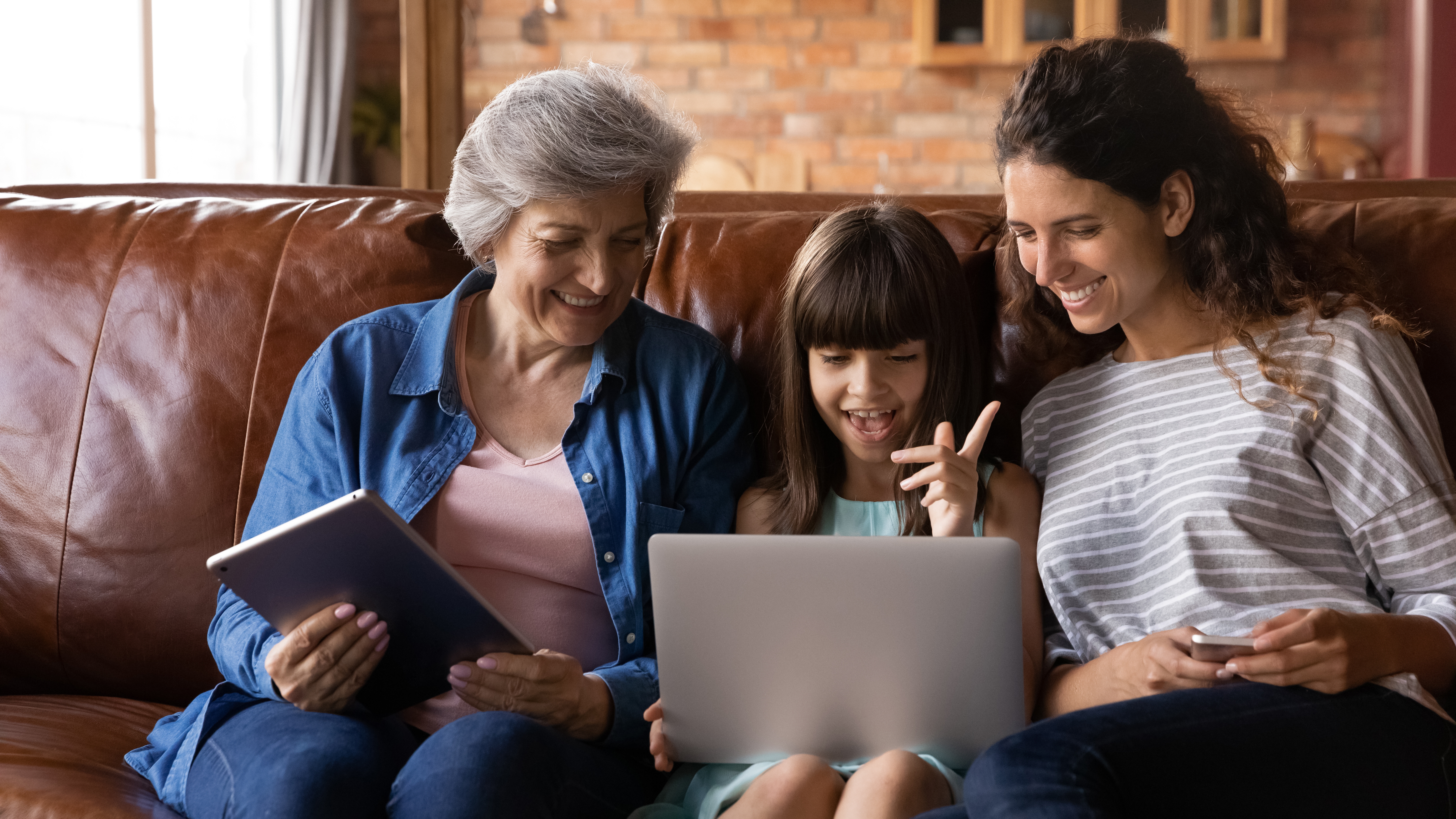 family talking on the couch infront of a laptop