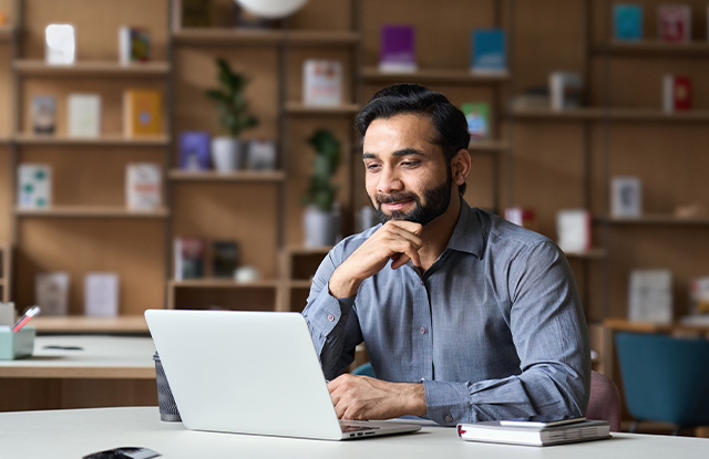 image of a male businessman sitting at list computer thinking