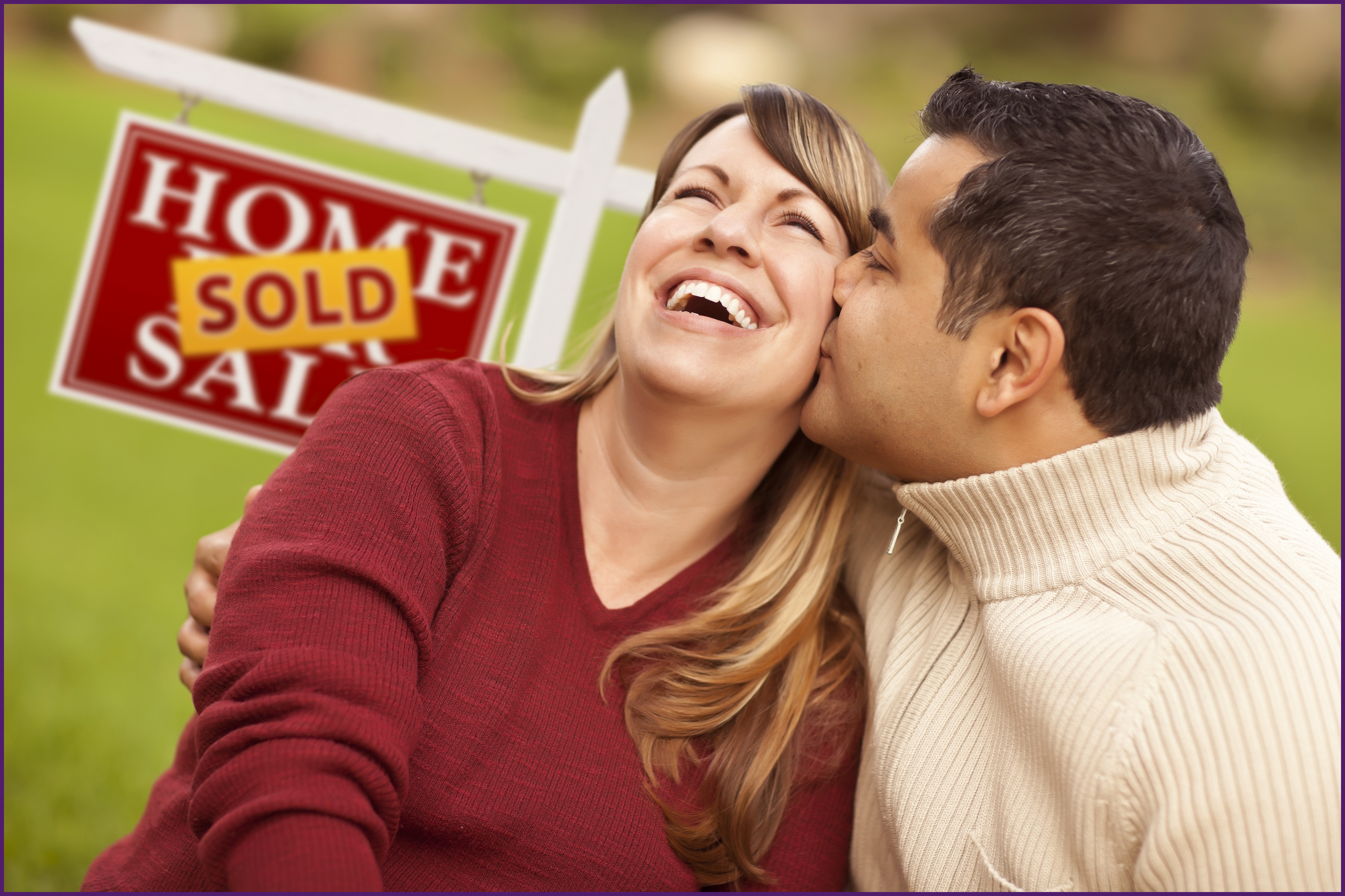 image of a couple in front of a sold sign