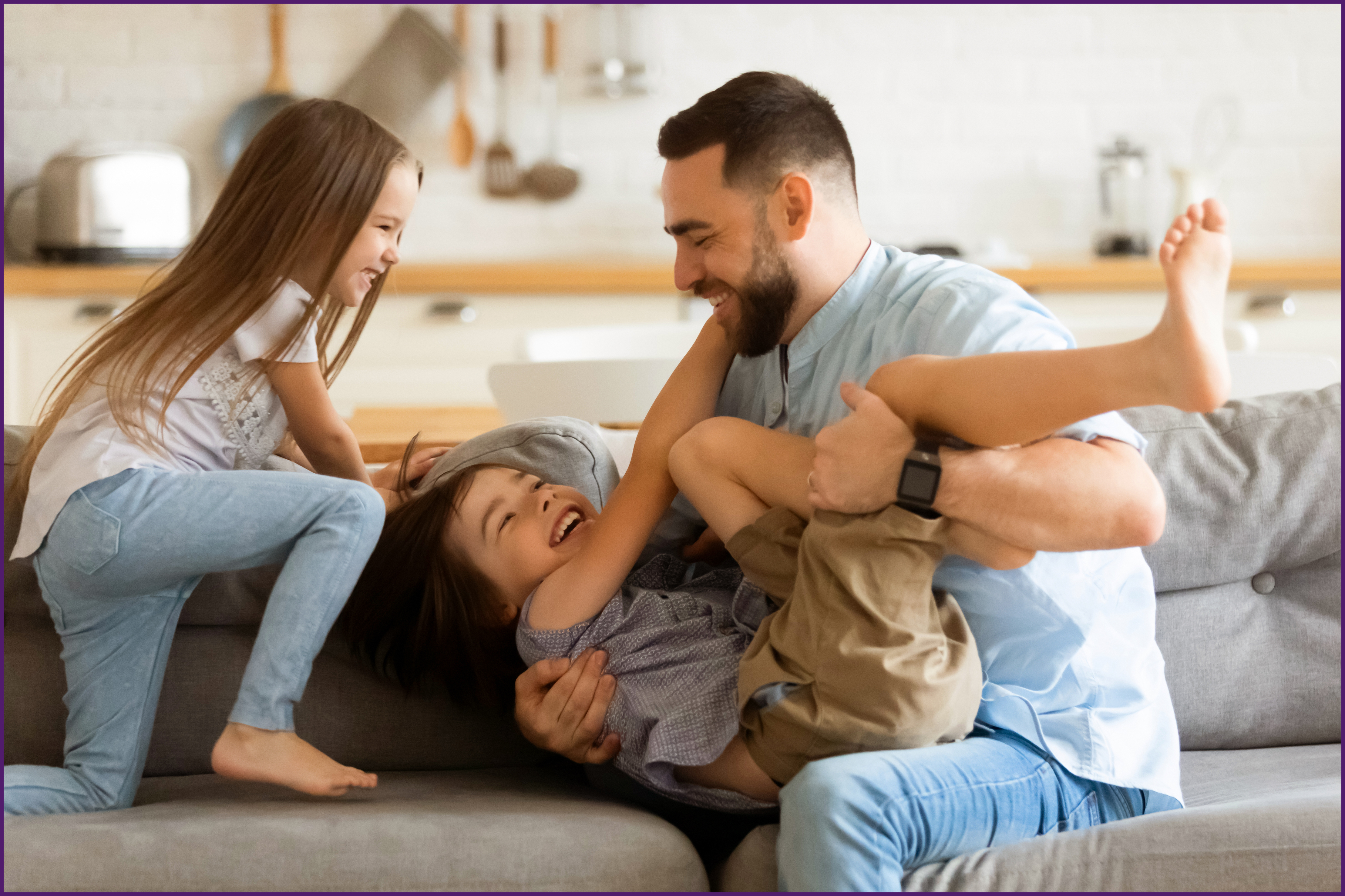 image of a father on the couch with his children