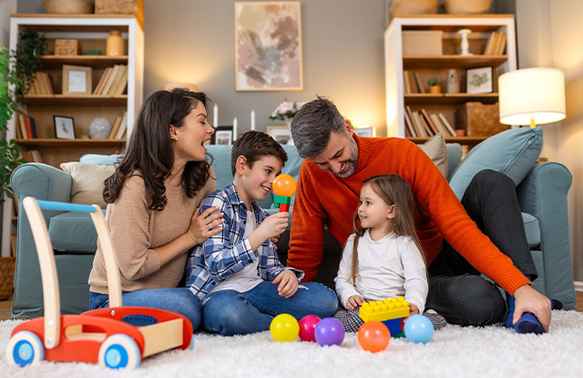 image of a family sitting in there living playing with there children