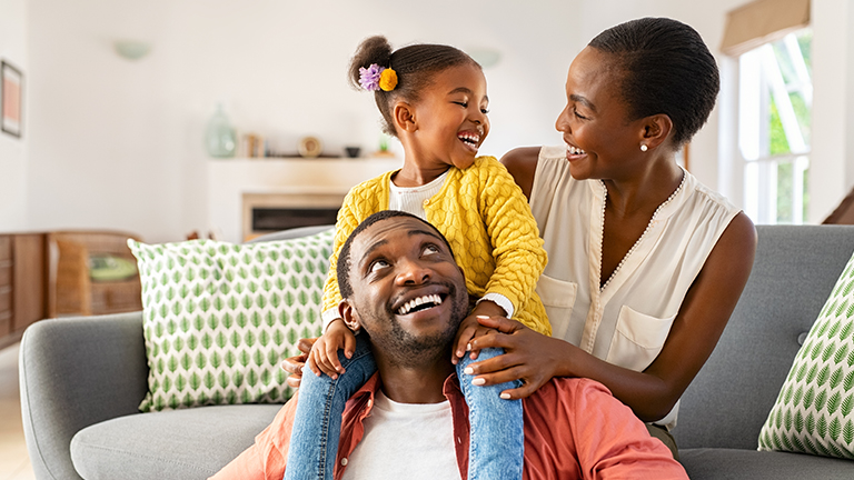 image of a family of three sitting on the couch