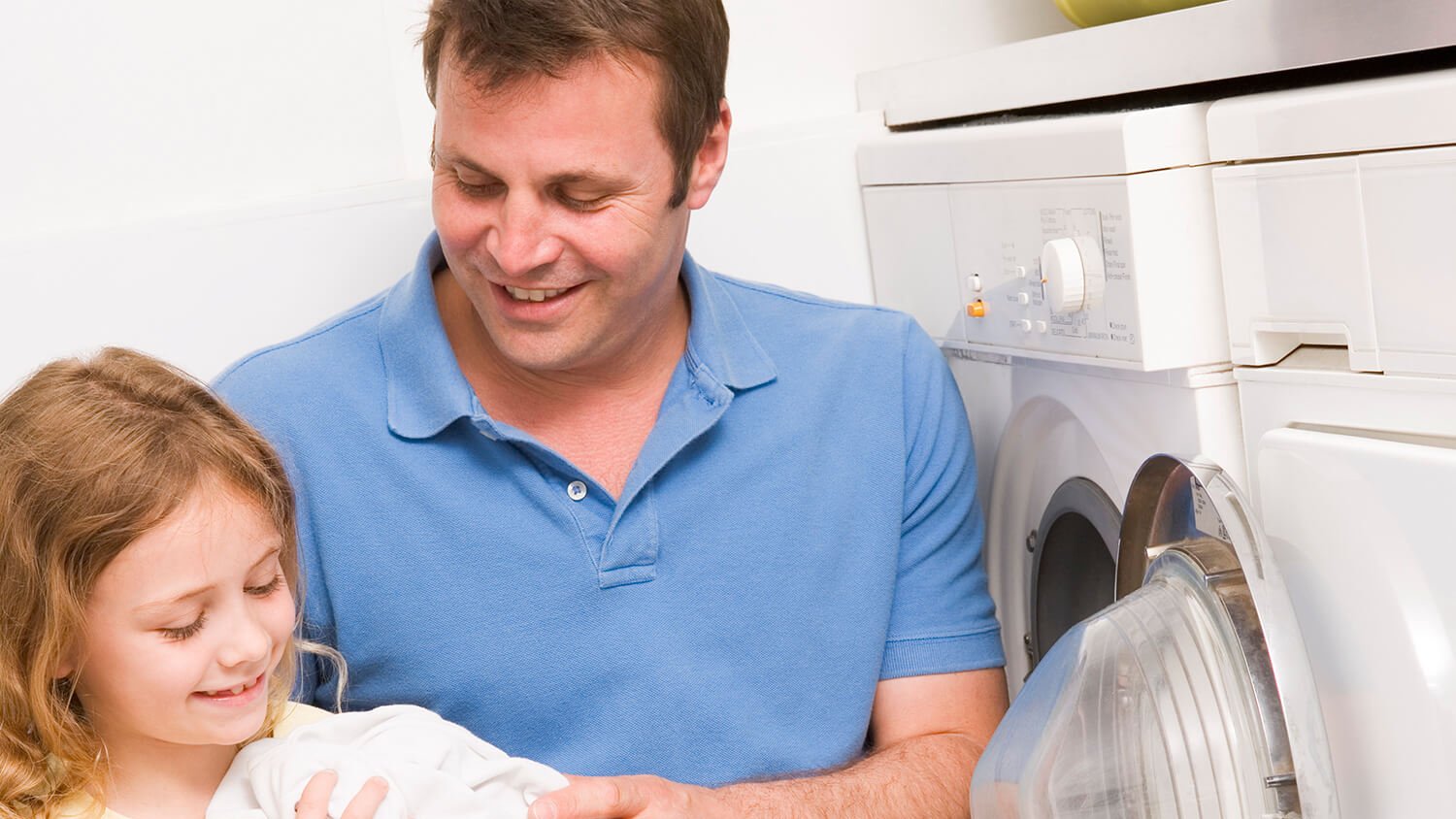 father and daughter doing laundry together