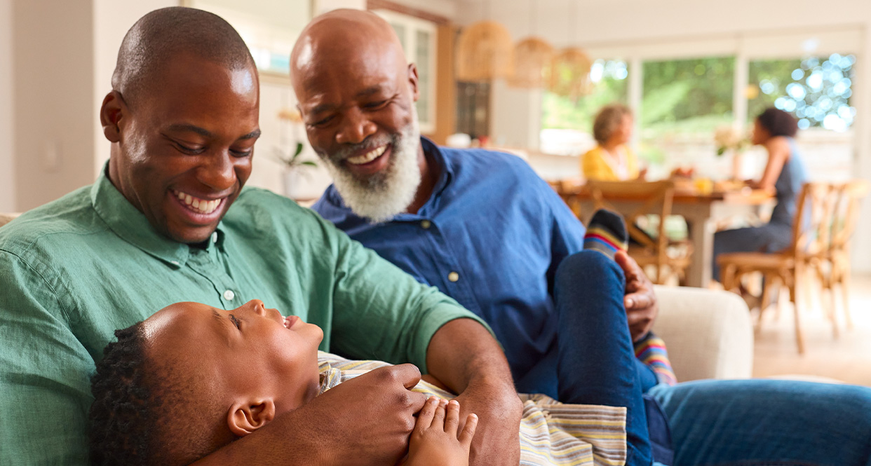 father, grandfather and grandson playing on the couch