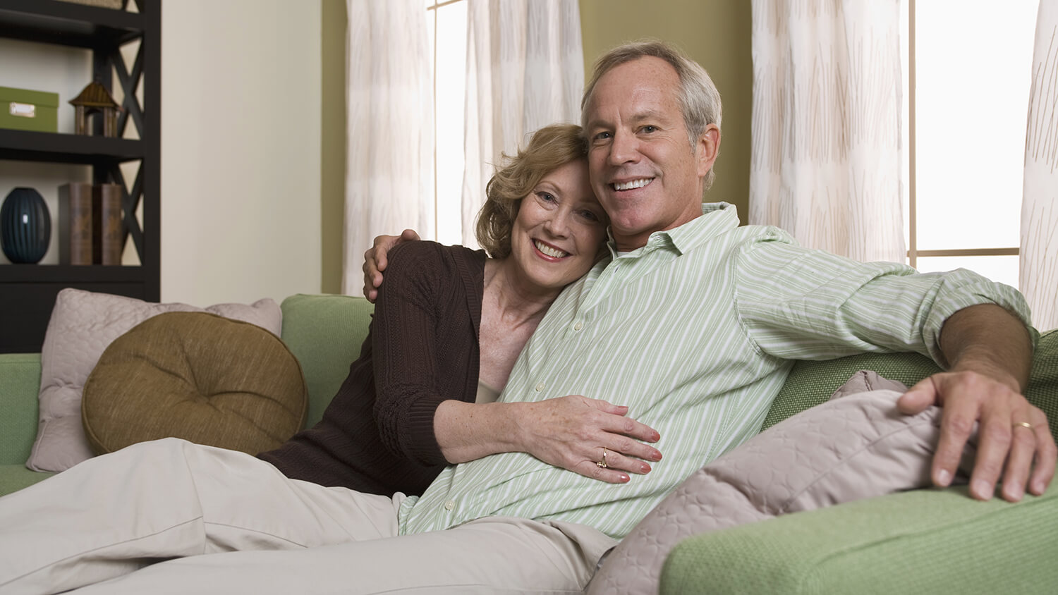 mature couple smiling on the couch together