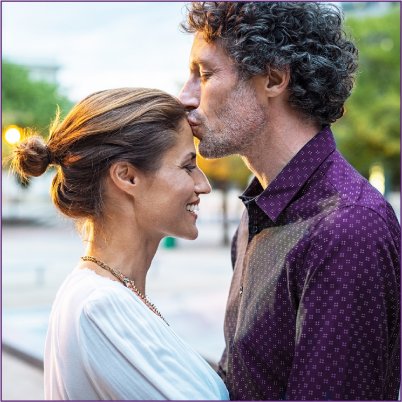 husband kissing his wife on the forehead