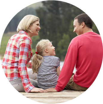 image of a mother and father with the daughter by a lake