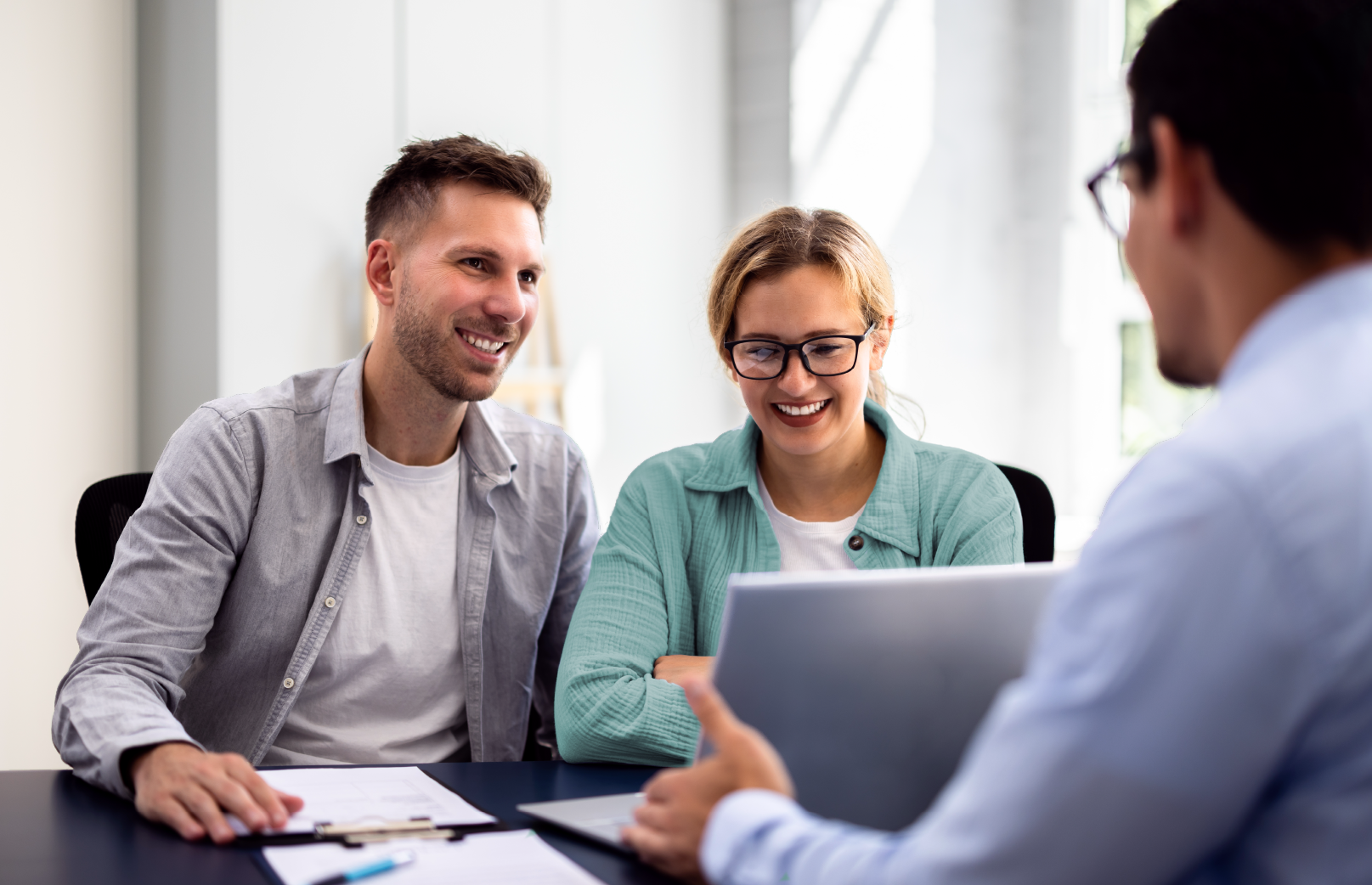 A happy couple talking to an agent